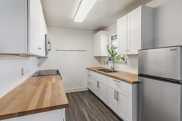 a kitchen with granite countertop a sink and a refrigerator