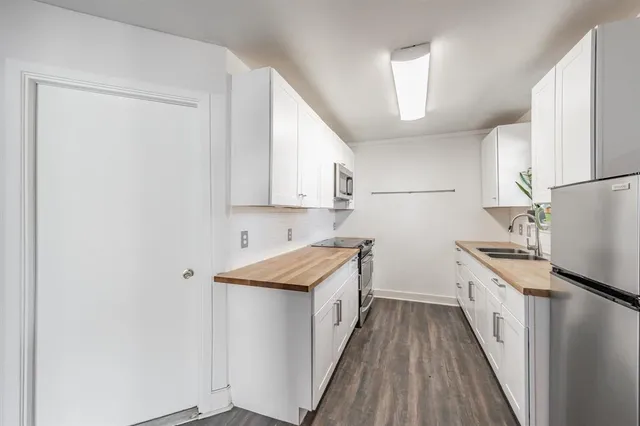 a kitchen with a sink a refrigerator and cabinets