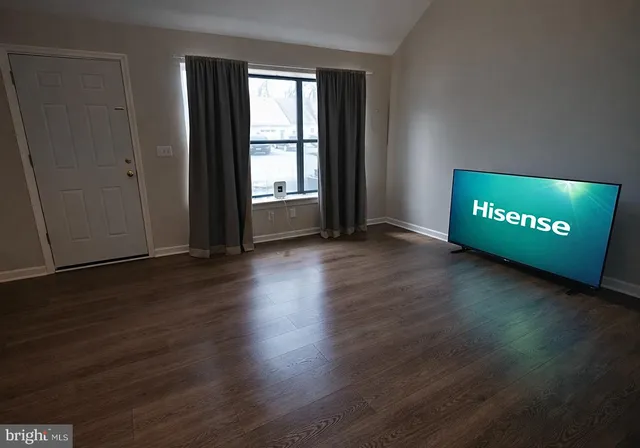 a view of a room with wooden floor and windows