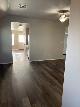 a view of empty room with wooden floor