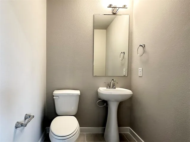 a bathroom with a sink mirror toilet and a mirror