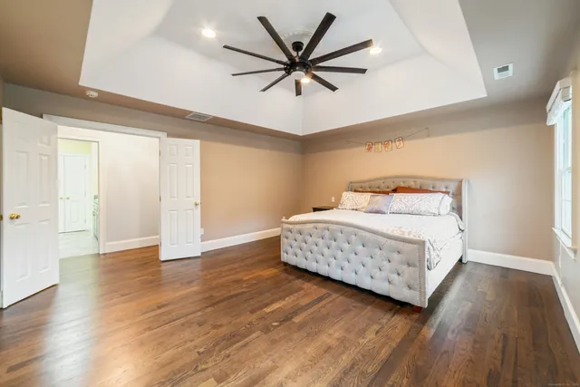 a bedroom with a bed and wooden floor