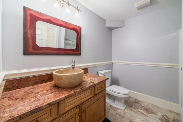 a bathroom with a toilet a sink and mirror