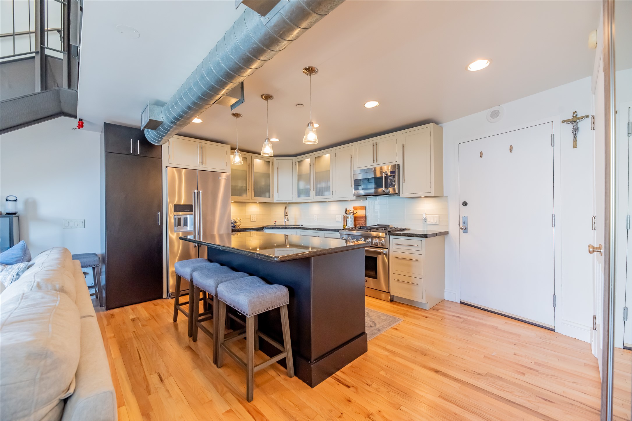 915 Franklin Street, Unit 9K Houston, TX 77002 - Photo 2 of 20 a kitchen with stainless steel appliances granite countertop a table chairs and a refrigerator