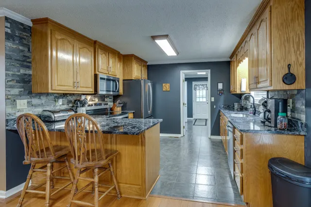 a kitchen with stainless steel appliances granite countertop refrigerator sink and stove