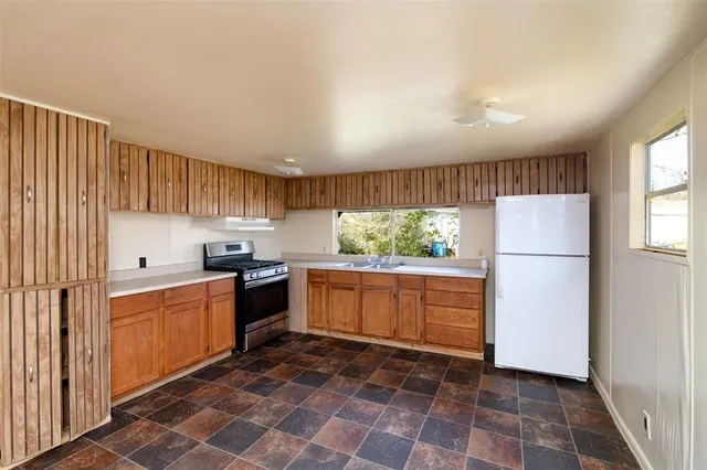 a kitchen with granite countertop a refrigerator and a sink