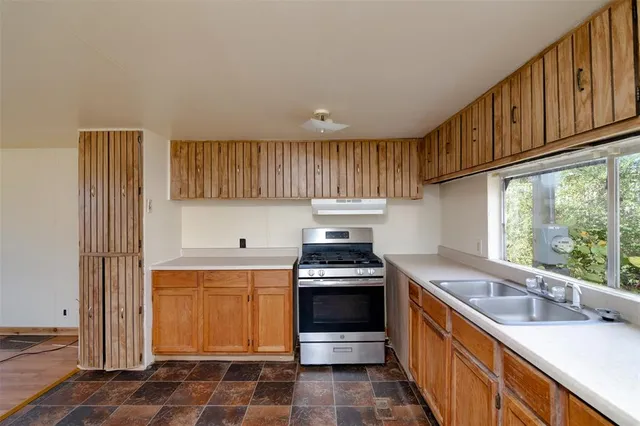 a kitchen with stainless steel appliances granite countertop a sink stove and cabinets