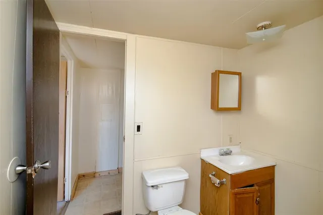 a bathroom with a toilet sink vanity and mirror