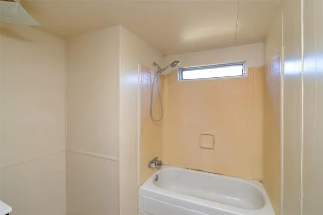 a white bath tub sitting next to a shower