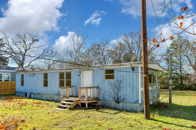 a backyard of a house with table and chairs