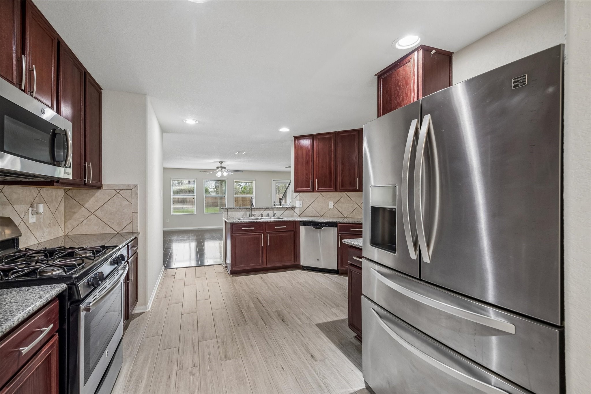 15642 South Fall Fern Circle Houston, TX 77044 - Photo 5 of 32 a kitchen with stainless steel appliances granite countertop a refrigerator stove and sink