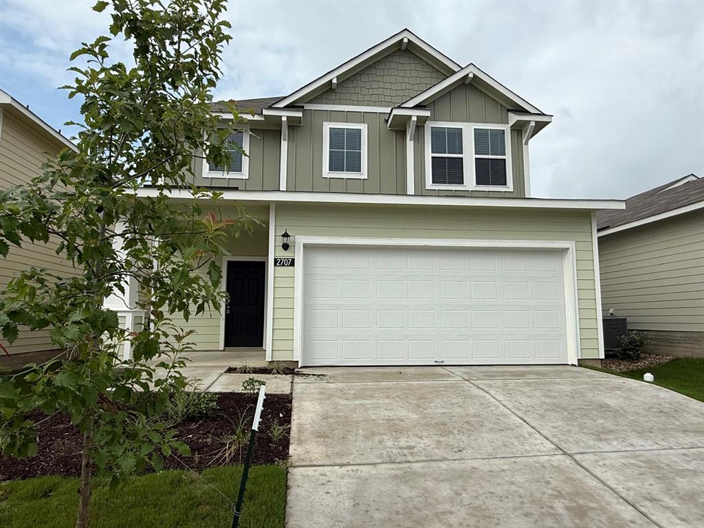2707 Totley Road Pflugerville, TX 78660 - Photo 2 of 39 View of front of home featuring an attached garage, concrete driveway, and board and batten siding
