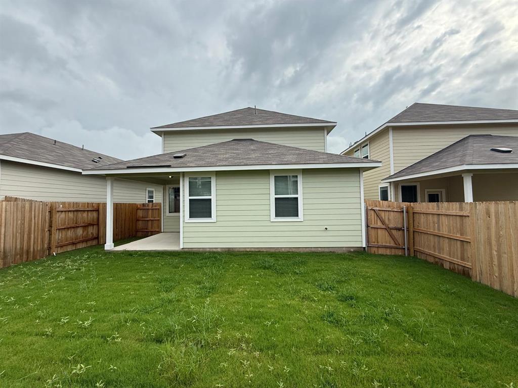2707 Totley Road Pflugerville, TX 78660 - Photo 4 of 39 Back of house featuring a patio area, roof with shingles, a fenced backyard, and a gate