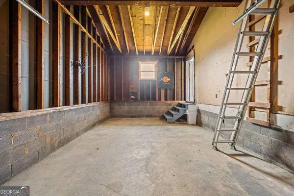 a view of an empty room with wooden floor and a ceiling fan