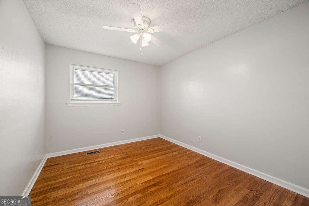 31 Jackson Way Fort Oglethorpe, GA 30742 - Photo 18 of 51 an empty room with a chandelier fan and wooden floor
