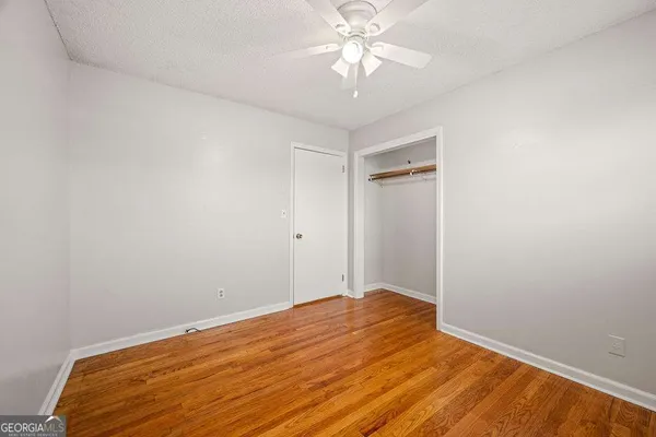 a brick house with a big yard and large trees