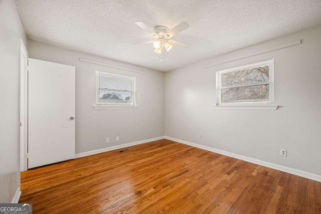 31 Jackson Way Fort Oglethorpe, GA 30742 - Photo 25 of 51 a view of an empty room with wooden floor and a ceiling fan