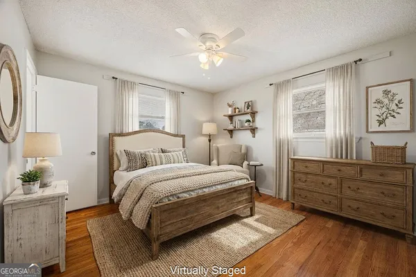 a view of empty room with wooden floor and ceiling fan
