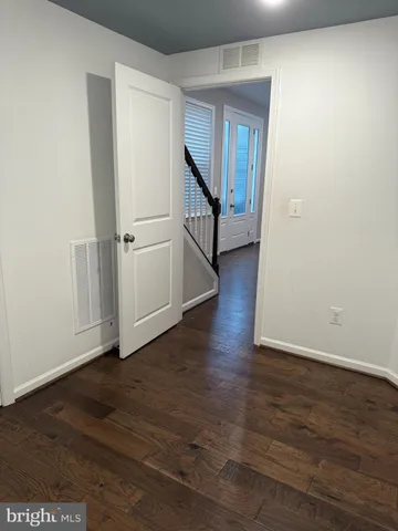 a view of a hallway with wooden floor and entryway