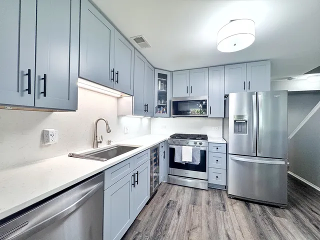 a kitchen with stainless steel appliances granite countertop a sink stove and refrigerator
