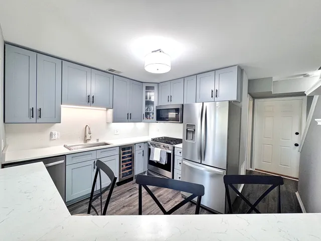 a kitchen with a table chairs refrigerator and cabinets