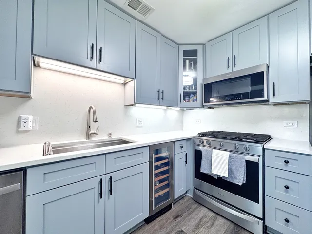 a kitchen with cabinets stainless steel appliances a sink and a microwave