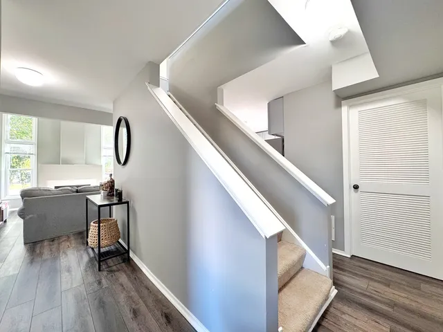 a view of entryway and kitchen with wooden floor