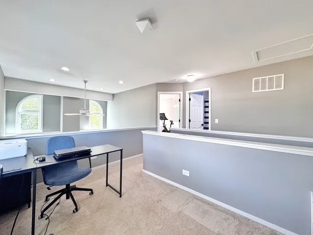 a view of a workspace with furniture and a window