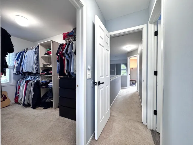a view of walk in closet with clothes and shoes