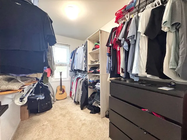 a view of walk in closet with clothes