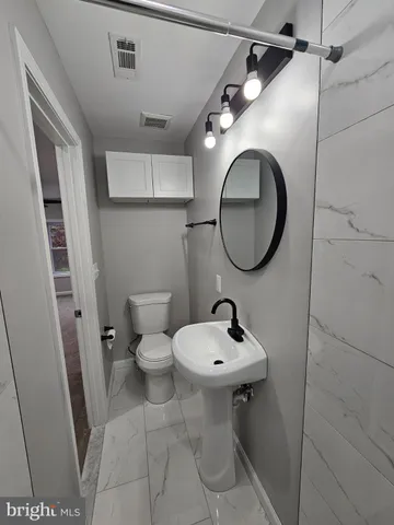 a bathroom with a sink a toilet and a mirror