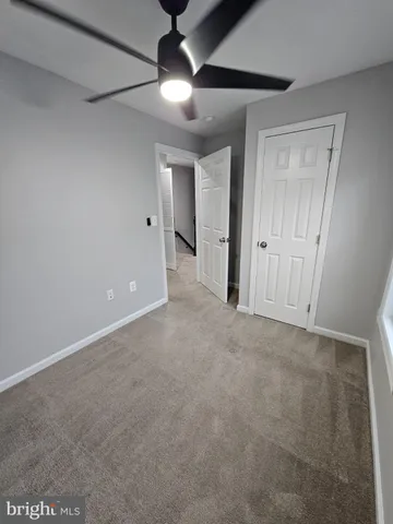 a view of an empty room with a ceiling fan