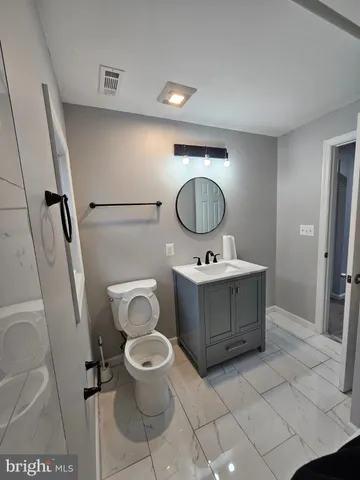 a bathroom with a toilet sink and mirror