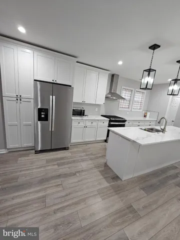 a large kitchen with stainless steel appliances kitchen island granite countertop a stove a refrigerator a sink and a oven