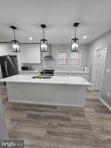 a large kitchen with kitchen island a sink stainless steel appliances and cabinets