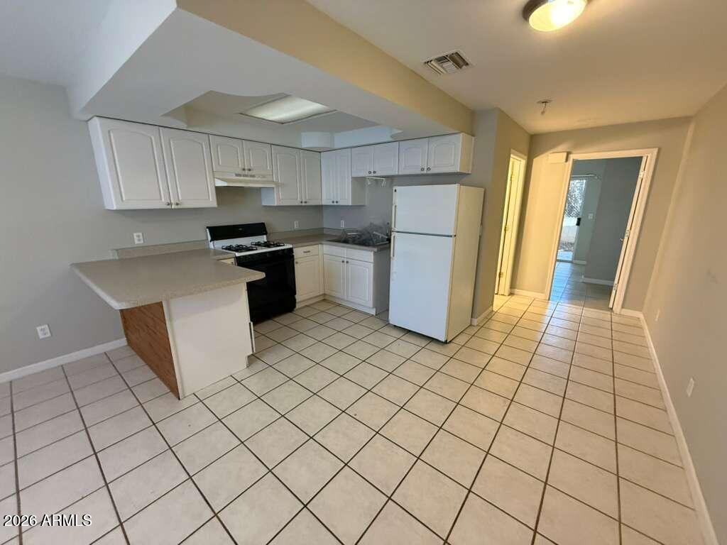 1810 East 8th Street, Unit C Douglas, AZ 85607 - Photo 4 of 14 a kitchen with stainless steel appliances a refrigerator sink and cabinets