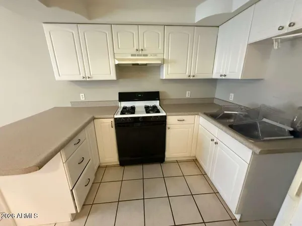 a kitchen with a stove sink and cabinets
