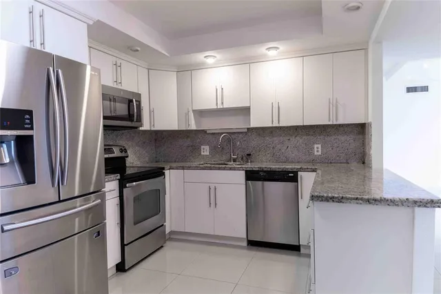 a kitchen with granite countertop stainless steel appliances and white cabinets