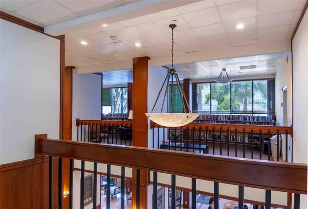 a view of a hallway with wooden floor and a living room