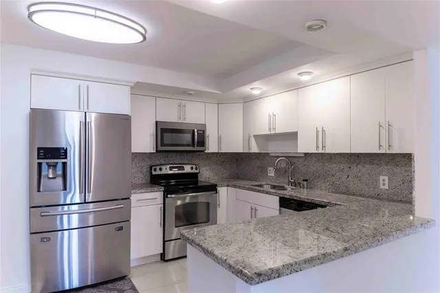 a kitchen with stainless steel appliances granite countertop a refrigerator a sink a stove a microwave and island