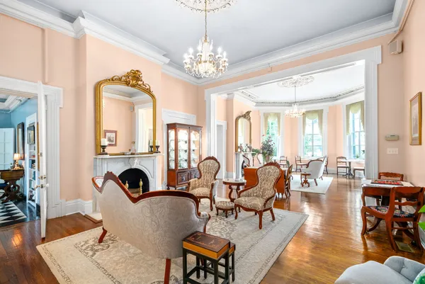 a dining room with furniture a chandelier and wooden floor