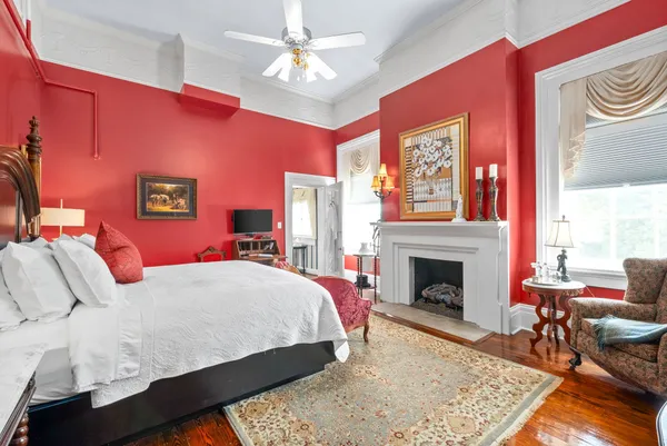 a kitchen with a stove and white cabinets with wooden floor