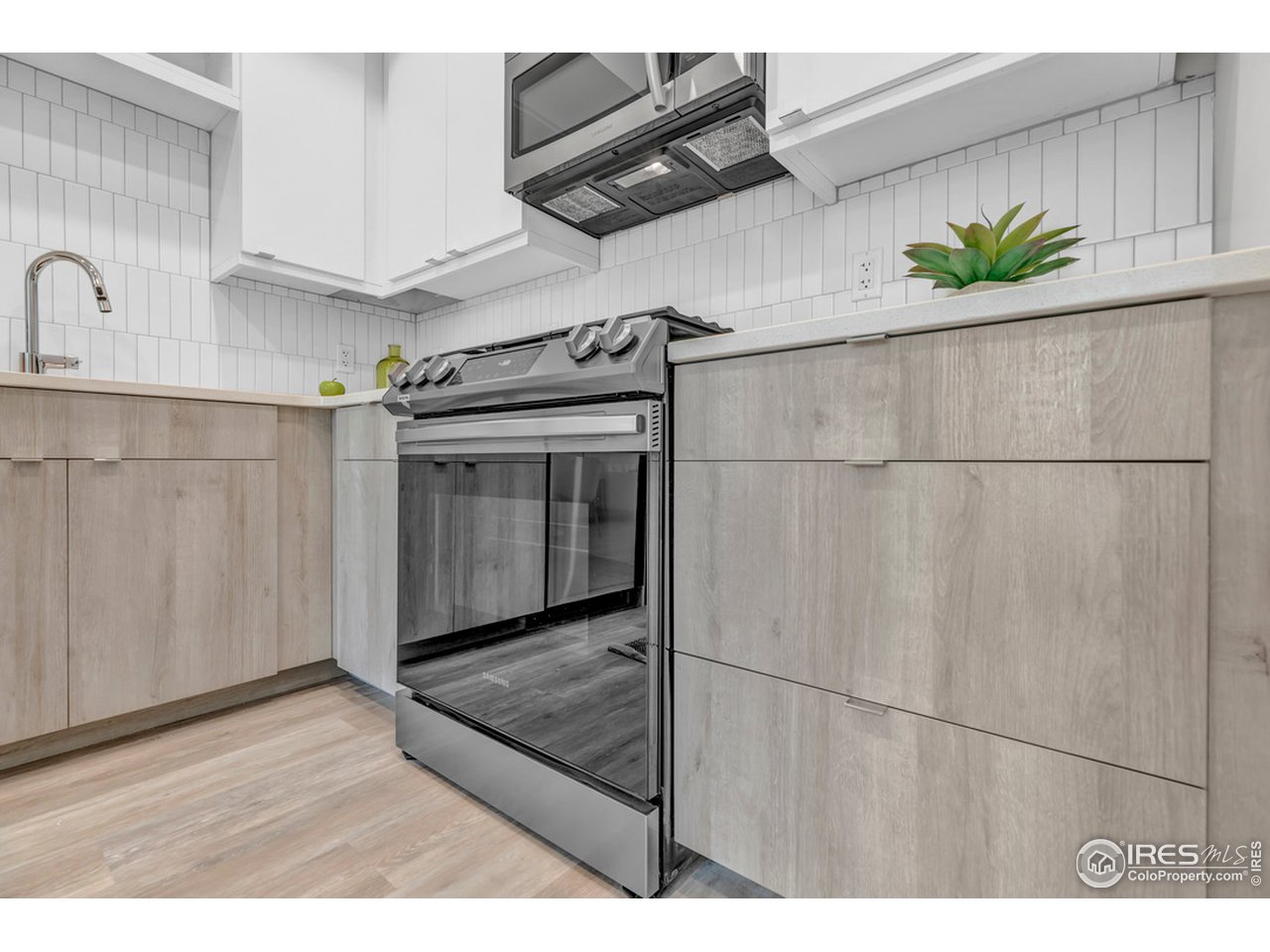 3261 Airport Road, Unit 204 Boulder, CO 80301 - Photo 9 of 36 a kitchen with stainless steel appliances kitchen island granite countertop a refrigerator a stove and a sink