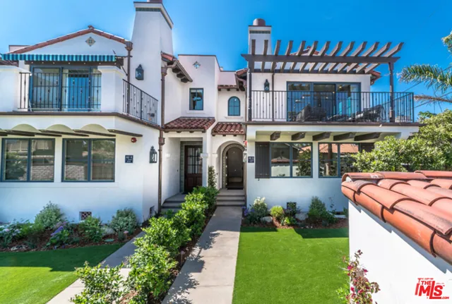 a front view of a house with a yard and potted plants