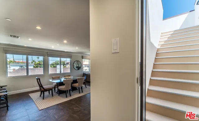 a view of a dining room with furniture a chandelier and wooden floor