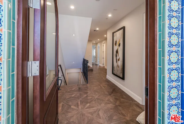 a view of a hallway with furniture and a chandelier