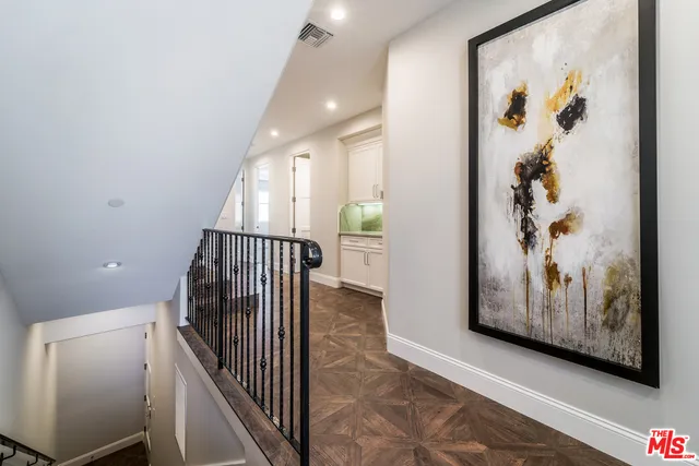 a view of a hallway with wooden floor and stairs