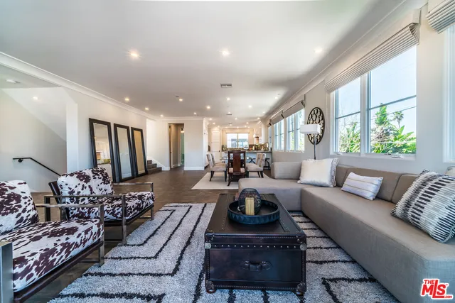 a living room with furniture fireplace and a large window