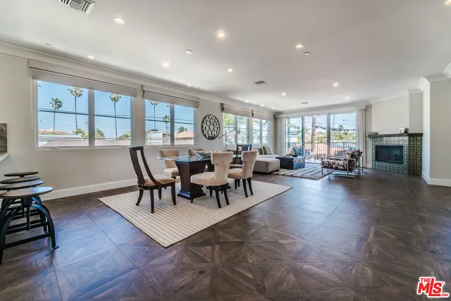 a living room with furniture large window and wooden floor