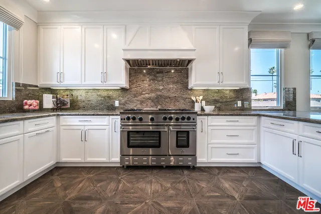 a kitchen with granite countertop white cabinets and stainless steel appliances